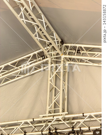Metal truss structure inside a large tent for an event setup in a public space Metal truss structure inside a large tent for an event setup in a public space 143158872