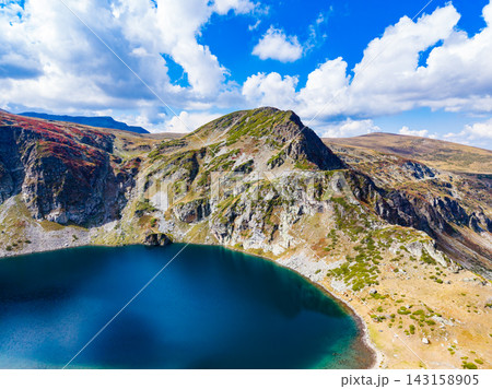 Mountain and lake view under a blue sky with clouds in a natural landscape during daytime Mountain and lake view under a blue sky with clouds in a natural landscape during daytime 143158905