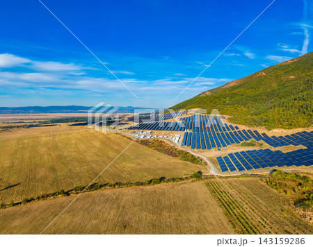 Solar panel installation in a field near a mountain under a clear blue sky Solar panel installation in a field near a mountain under a clear blue sky 143159286