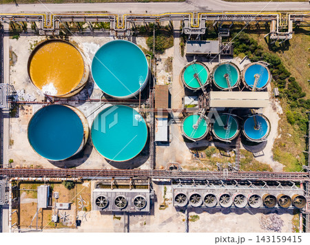 Industrial water treatment facility with multiple circular tanks in various colors and pipes Industrial water treatment facility with multiple circular tanks in various colors and pipes 143159415