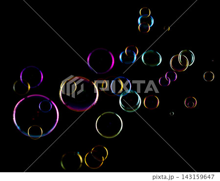 Soap Bubbles floating over black background isolated. Rainbow colorful air balls fly over many sizes. Shampoo bubbles sphere form shiny glossy blowing transparent purity in group. Soap Bubbles floating over black background isolated. Rainbow colorful air balls fly over many sizes. Shampoo bubbles sphere form shiny glossy blowing transparent purity in group. 143159647
