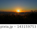 水平線に沈む夕日を背にして、すすきの野原が広がっている秋の情景 143159753