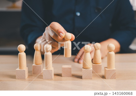 Hand lifts a wooden figure above blocks with other people, representing recruitment, candidate selection, employee promotion, talent choice, ranking, career advancement, 143160068