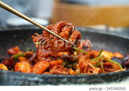 Picking Up Spicy Stir-Fried Webfoot Octopus with Chopsticks, Authentic Korean Seafood Dish (Jjukkumi-bokkeum) 143160262