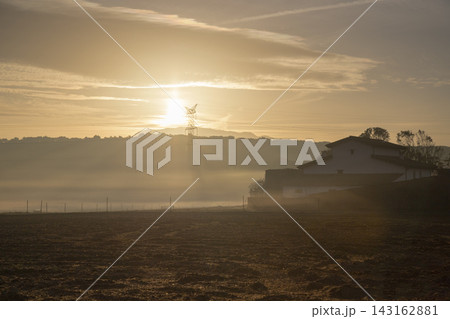 Rural landscape with farm house during foggy sunrise Rural landscape with farm house during foggy sunrise 143162881
