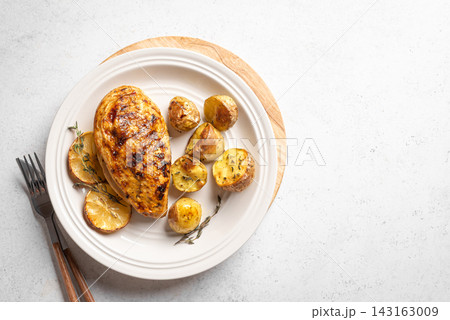 Oven roasted lemon garlic chicken and potatoes on plate Oven roasted lemon garlic chicken and potatoes on plate 143163009