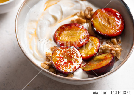Roasted plums with yogurt, honey and nuts Roasted plums with yogurt, honey and nuts 143163076