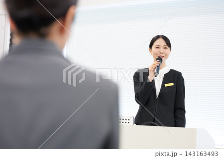 セミナーでマイクを持ち笑顔で話す司会者 143163493