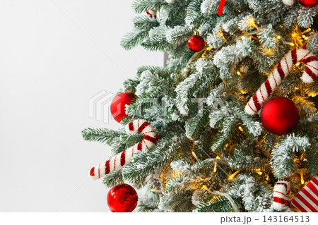 Christmas tree with frosted snowy branches decorated with red and white ornaments with lights Christmas tree with frosted snowy branches decorated with red and white ornaments with lights 143164513