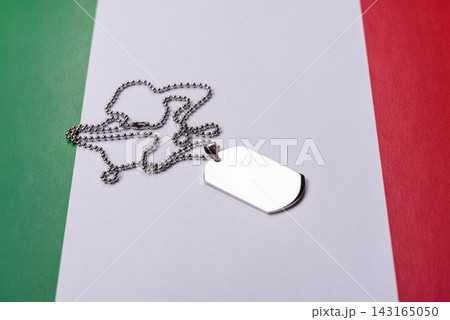 A dog tag on the Italian flag, serving as a conceptual backdrop representing Europe's defense A dog tag on the Italian flag, serving as a conceptual backdrop representing Europe's defense 143165050