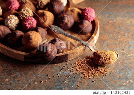 Chocolate truffles on a wooden tray. 143165423