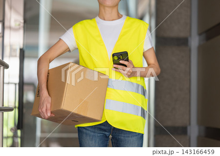 荷物を運ぶ笑顔の女性配達員 143166459