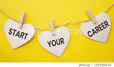 Start Your Career text on wooden heart tags hanging on rope with clothespins over yellow background. Career development and professional growth concept with copy space. 143166810