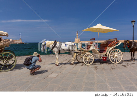 Horse Carriage and Photographer at Chania Old Harbor, Crete, Greece Horse Carriage and Photographer at Chania Old Harbor, Crete, Greece 143168015