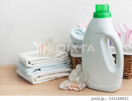 Laundry detergent bottle with fresh clean towels and orchids 143168631