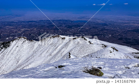 残雪の岩木山 頂上からの俯瞰 赤倉ルートの稜線と眼下に広がる津軽平原 残雪の岩木山 頂上からの俯瞰 赤倉ルートの稜線と眼下に広がる津軽平原 143168769