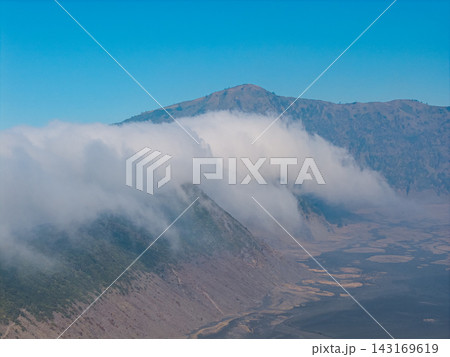 Mist wraps mountain slopes with soft, swirling grace Mist wraps mountain slopes with soft, swirling grace 143169619