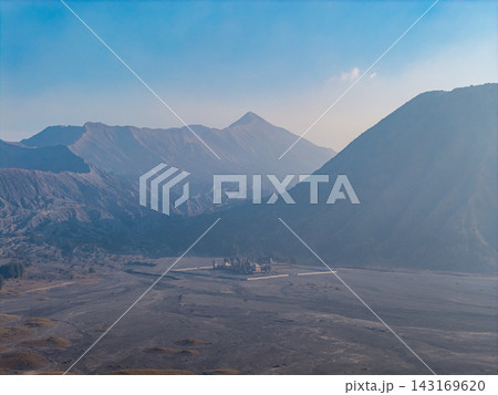 Majestic mountains loom over barren volcanic plain Majestic mountains loom over barren volcanic plain 143169620