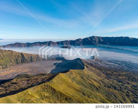 Vast crater yawns under clear blue skies Vast crater yawns under clear blue skies 143169991