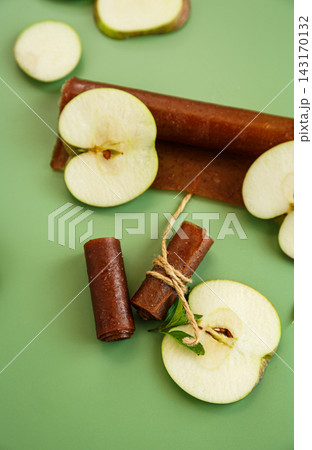 Dried apple fruit snack with mint leaves on green background Dried apple fruit snack with mint leaves on green background 143170132