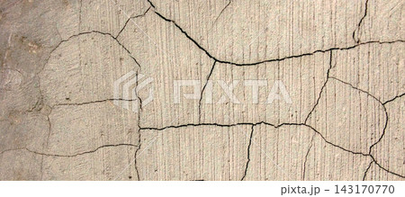 A detailed close-up shot showing a cracked, textured concrete wall or pavement surface. A detailed close-up shot showing a cracked, textured concrete wall or pavement surface. 143170770