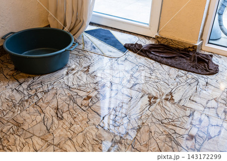 puddle of water, basin and wet floor cloth in home puddle of water, basin and wet floor cloth in home 143172299