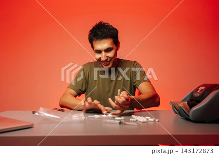 Criminal activity scene depicting illegal narcotics preparation, featuring cocaine lines, cash counter, pharmaceutical drugs, syringes, packaging materials on crimson surface. Criminal activity scene depicting illegal narcotics preparation, featuring cocaine lines, cash counter, pharmaceutical drugs, syringes, packaging materials on crimson surface. 143172873