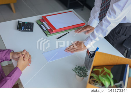 Office Employee Submitting Resignation Letter to Manager on Desk with Moving Box. 143173344