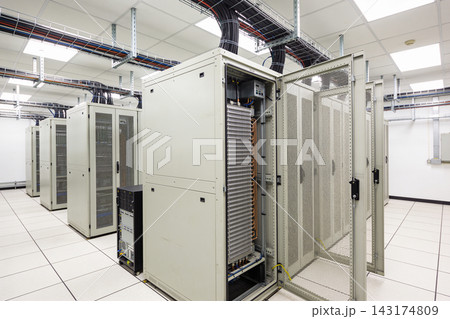 Modern data center server room with rows of high performance computing hardware and cooling units 143174809