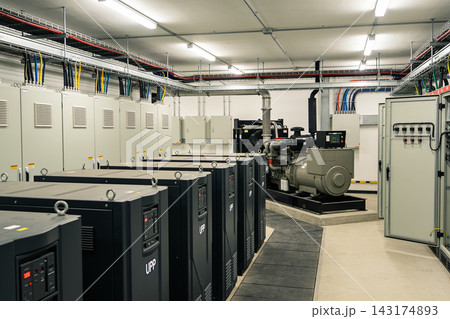 Industrial power room featuring rows of backup generators and electrical control cabinets Industrial power room featuring rows of backup generators and electrical control cabinets 143174893