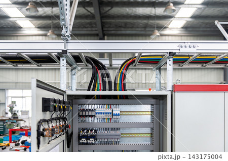 Industrial electrical control panel with colorful wiring in a modern manufacturing facility Industrial electrical control panel with colorful wiring in a modern manufacturing facility 143175004