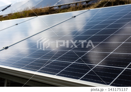 Close up of modern photovoltaic solar panels installed in a field for renewable energy generation 143175137