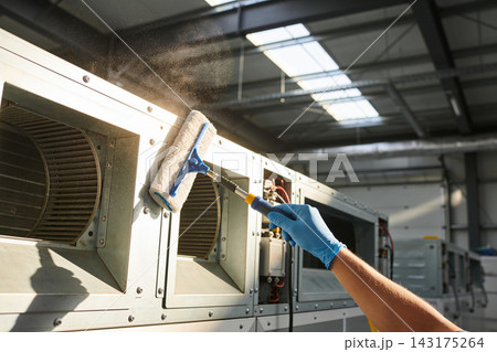 Professional technician cleaning industrial ventilation system with a specialized sponge tool 143175264