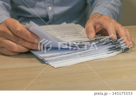 Office worker hands sorting paper documents Office worker hands sorting paper documents 143175553