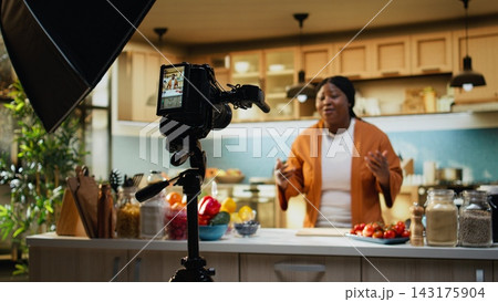 African american influencer, cooking video, recipe at home, behind the scenes, filming step by step cooking process and meal preparation. Creating content for social media platforms. 143175904