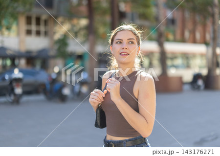 Young woman walks along city street Young woman walks along city street 143176271