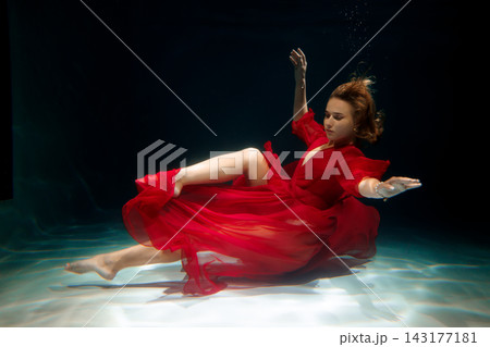 Deep aquatic scene featuring striking red gown and silent ambiance Deep aquatic scene featuring striking red gown and silent ambiance 143177181