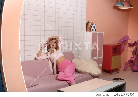 Chic individual resting casually on sleek pastel furniture space 143177504