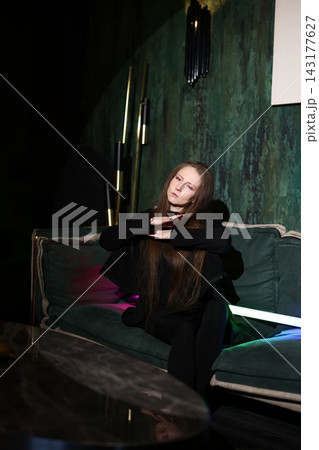 Contemplative artist white woman in pensive pose on neon sofa Contemplative artist white woman in pensive pose on neon sofa 143177627