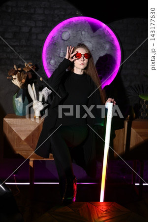 Confident woman in tailored attire with vibrant lighting Confident woman in tailored attire with vibrant lighting 143177630