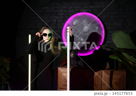 Female model posing with neon light and indoor plants backdrop Female model posing with neon light and indoor plants backdrop 143177653