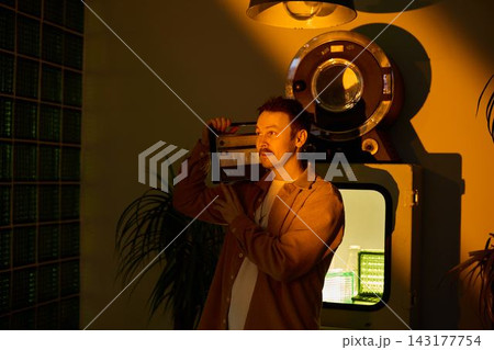 Retro radio scene. Man showcasing classic radio amidst retro decor 143177754