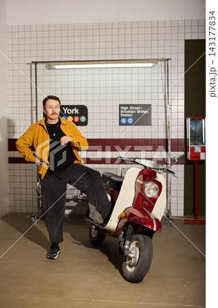 Casual man exhibits confidence while standing with scooter underground Casual man exhibits confidence while standing with scooter underground 143177834
