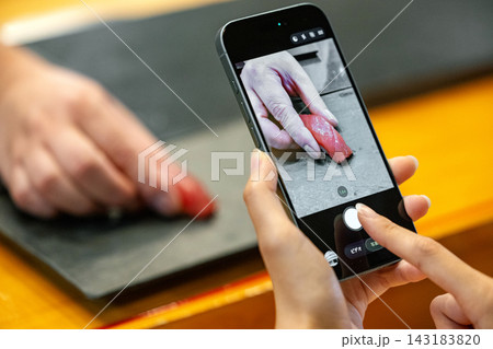 高級寿司に来て記念にスマホで撮影をする女性の手元 高級寿司に来て記念にスマホで撮影をする女性の手元 143183820
