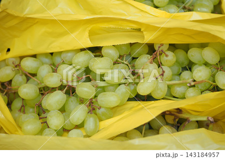 Bunches of green grapes in yellow bags at a market 143184957
