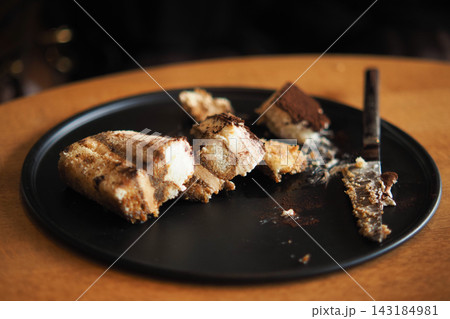 Dessert plate with slices of cake and a knife after enjoying a meal 143184981