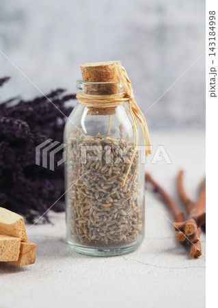 Lavender and cinnamon displayed with a glass bottle of dried lavender Lavender and cinnamon displayed with a glass bottle of dried lavender 143184998