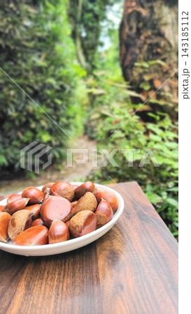 秋の味覚 緑を背景に皿に盛られた採れたての栗 秋の味覚 緑を背景に皿に盛られた採れたての栗 143185112