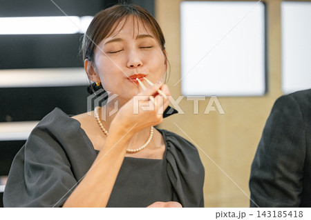 寿司屋でマグロを食べる若い女性 寿司屋でマグロを食べる若い女性 143185418