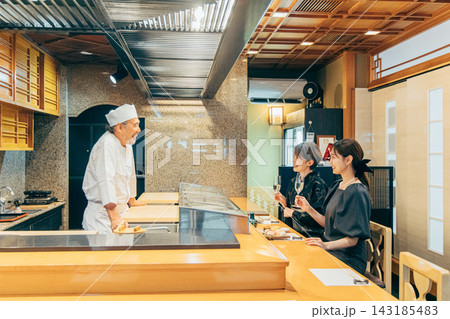 寿司屋で大将と会話する上品な親子 143185483